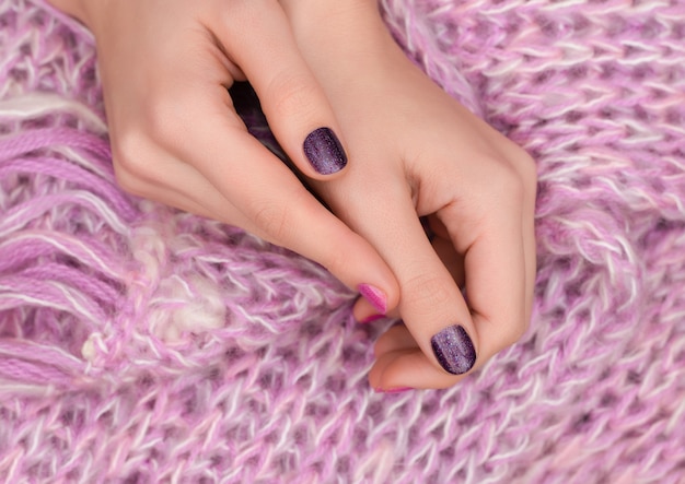 Pink nail design. Manicured female hands on pink background.