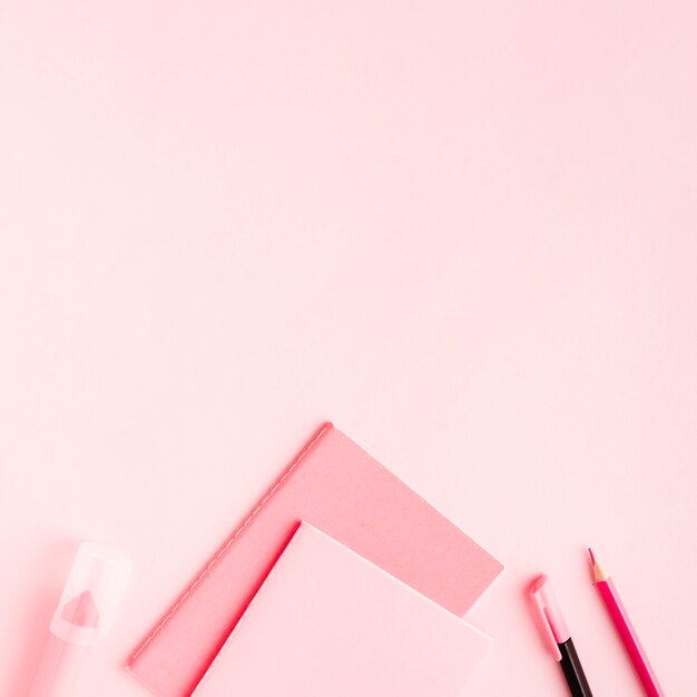 Pink office supplies on colored surface