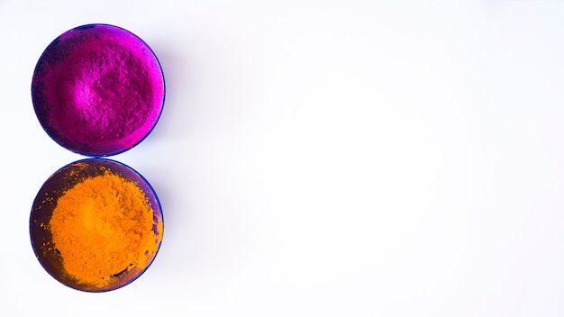 Pink and an orange holi color powder in the bowl on white background