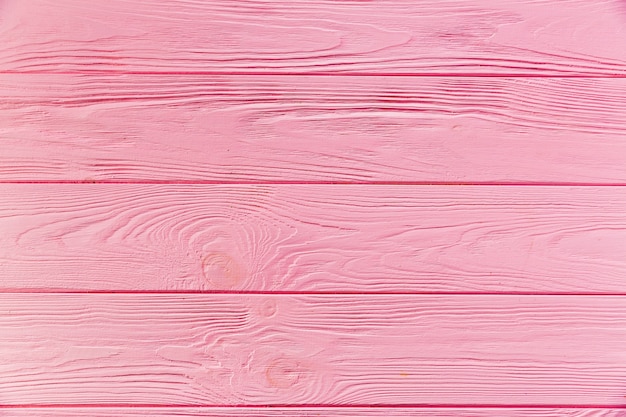 Pink painted rough wooden surface