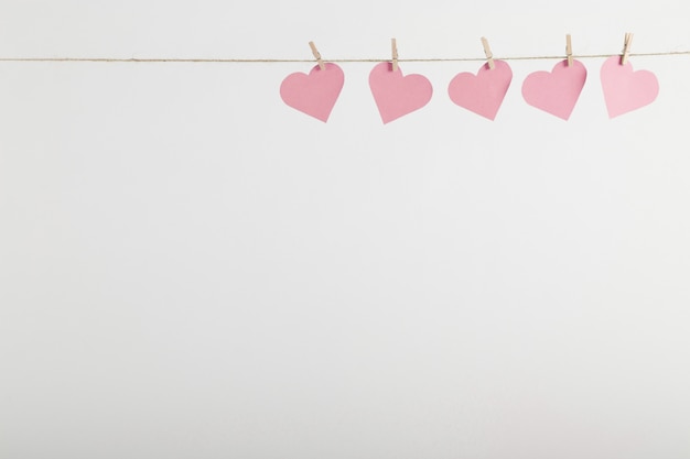 Pink paper hearts hanging on rope