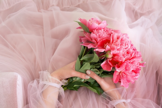 Free photo pink peony flowers bouquet in female hands