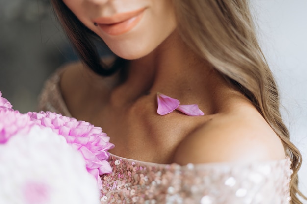 Free Photo pink petals lie on the shoulders of a beautiful sensitive woman