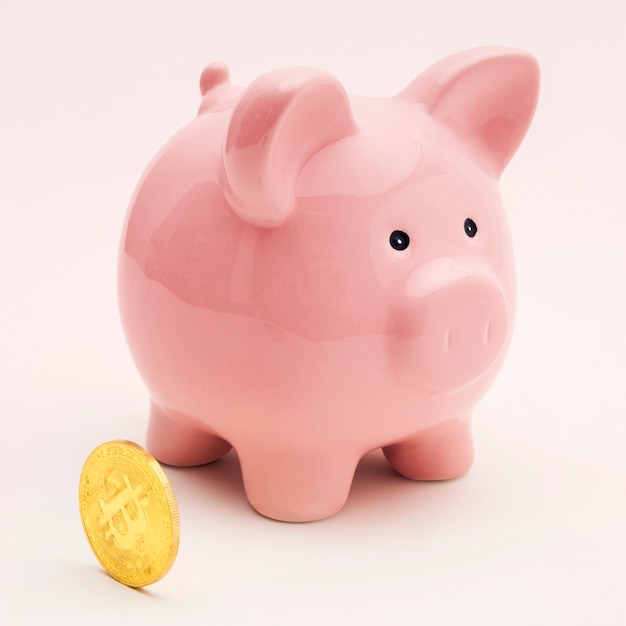 Free photo pink piggy bank with a bitcoin