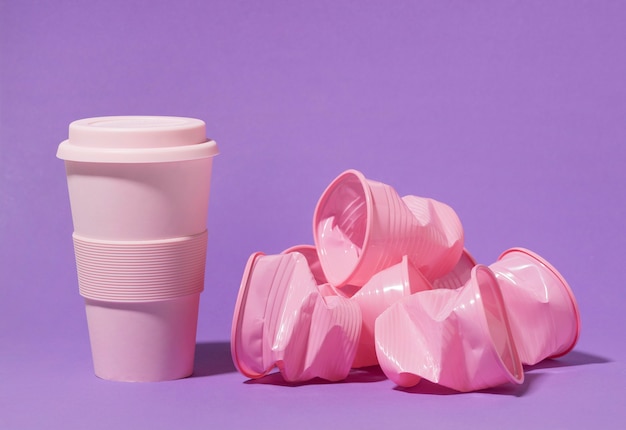 Free photo pink reusable cup with plastic cups