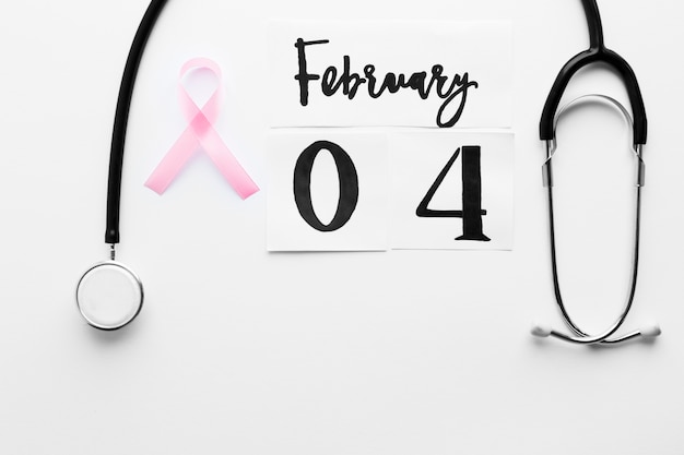 Free Photo pink ribbon between stethoscope and date