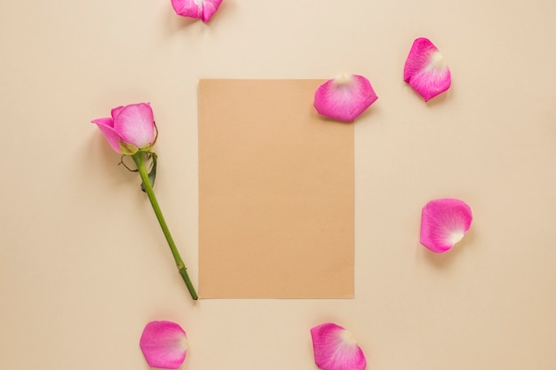 Free Photo pink rose flower with paper on table