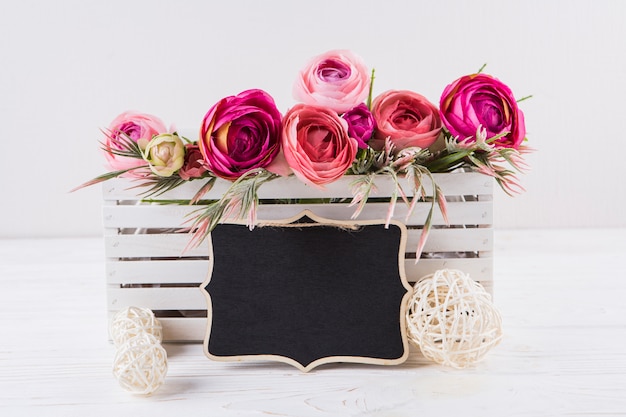 Free Photo pink rose flowers with small chalkboard on table 