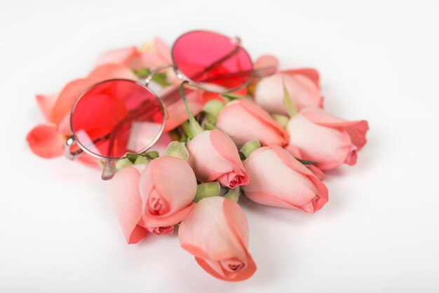 Pink roses with sunglasses on table 