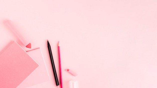 Free photo pink set of office tools on colored surface