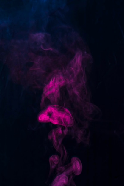 Pink smoke spread over the black background