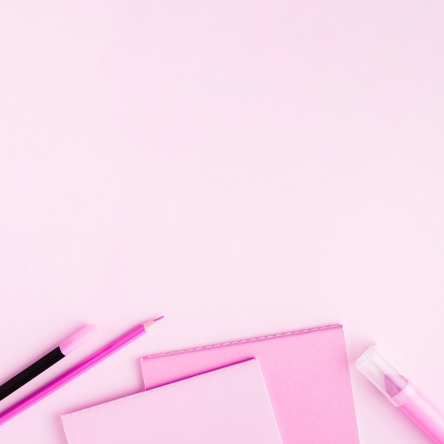 Pink stationery set on colored surface