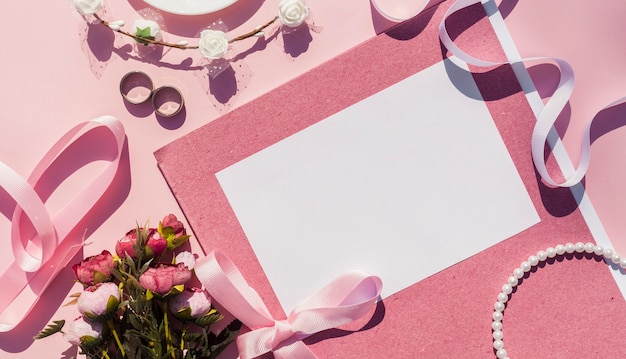 Free photo pink wedding invitation next to wedding items