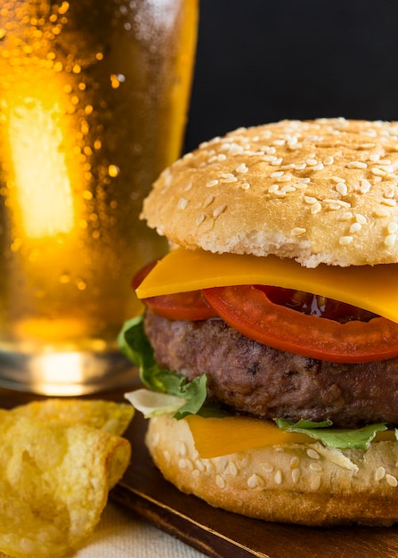 Pint of beer with cheeseburger and chips