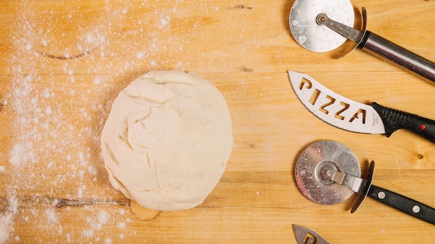 Free photo pizza cutters and knives near dough