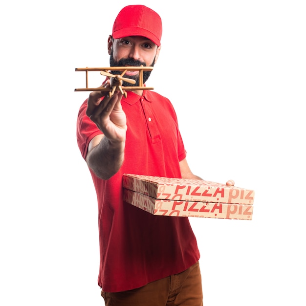 Free photo pizza delivery man holding a wooden toy airplane