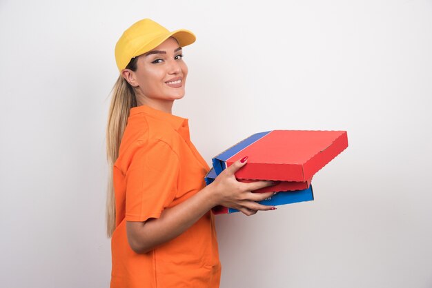 Pizza delivery woman holding pizza boxes with peaceful face on white space