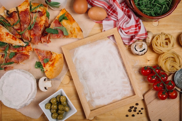 Free photo pizza and ingredients near frame