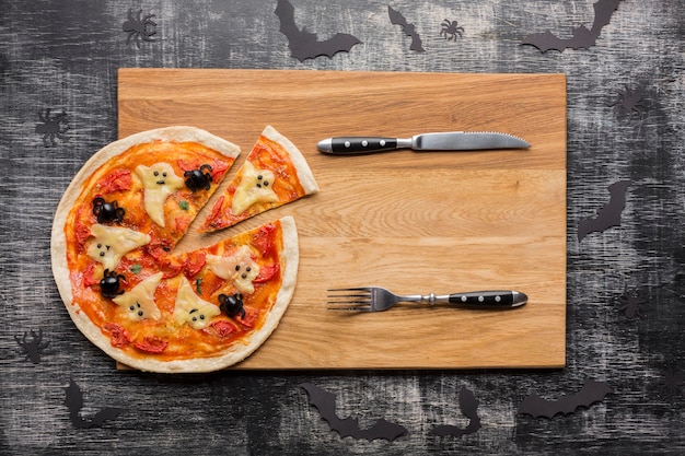 Free photo pizza slices with halloween ghosts and cutlery