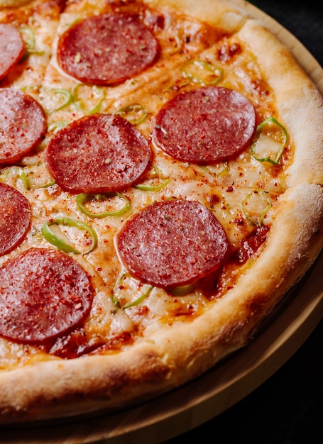 Pizza with pepperoni slices and tomato sauce.