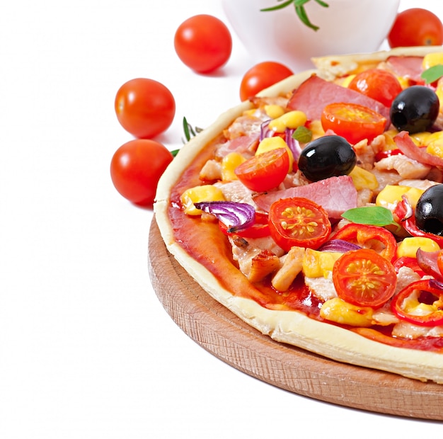 Pizza with vegetables, chicken, ham and olives isolated on white