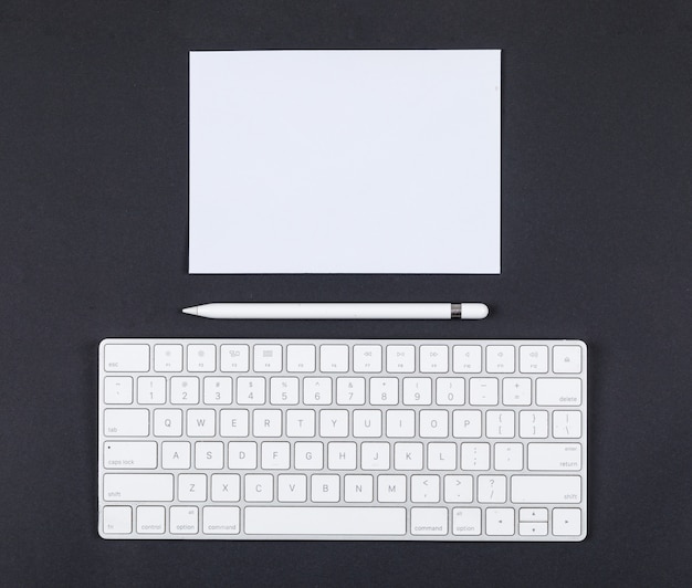 Free photo planning concept with pencil, keyboard, paper on black background top view. space for text. horizontal image