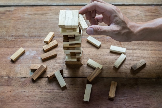 Planning, risk and strategy in business, businessman and engineer gambling placing wooden block on a tower.