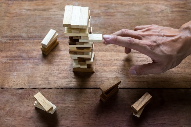 Planning, risk and strategy in business, businessman and engineer gambling placing wooden block on a tower.