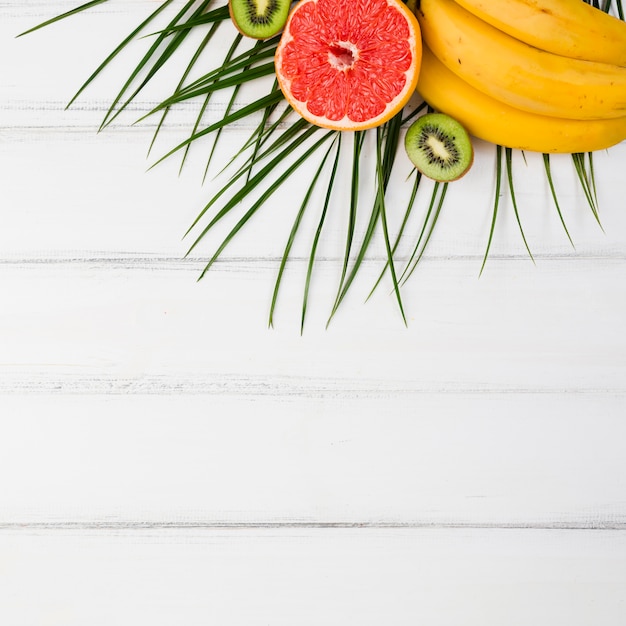 Free photo plant leaves near fresh exotic fruits on board