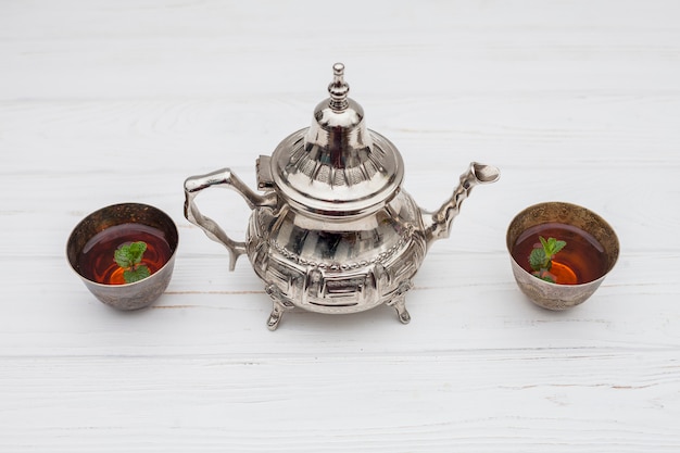 Plants in cups of tea near vintage teapot