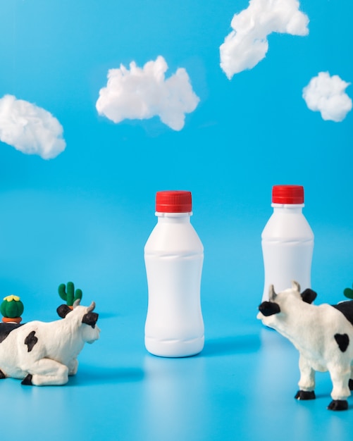 Free photo plastic milk bottles, toy cows and clouds