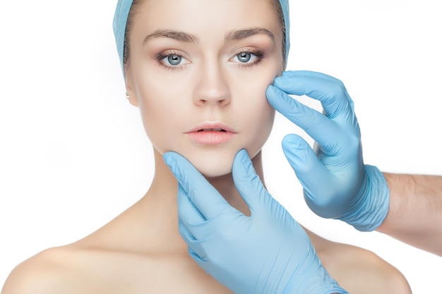 Free Photo plastic surgery concept doctor hands in gloves touching woman face