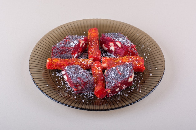 Plate of candied fruit pulps placed on white background. High quality photo