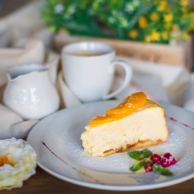 A plate of cheesecake piece garnished with apricot slices