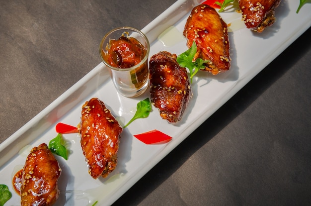 Free photo plate of chicken wings on grunge black background