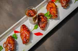 Free photo plate of chicken wings on grunge black background