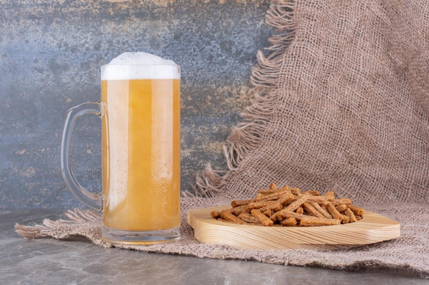 Plate of crackers with beer on marble table