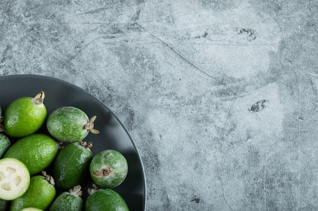 Free photo plate of feijoa fruits on marble background. high quality photo