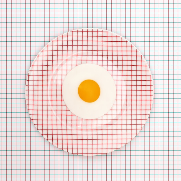 Free photo plate of a fried egg on a table with a geometric pattern