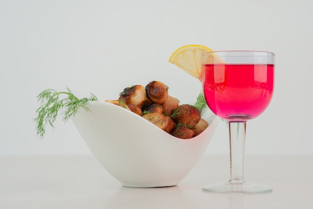 Plate of fried potato and glass of juice .