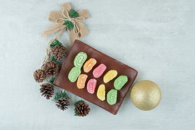 A plate full of marmalde and big Christmas ball on white background. High quality photo