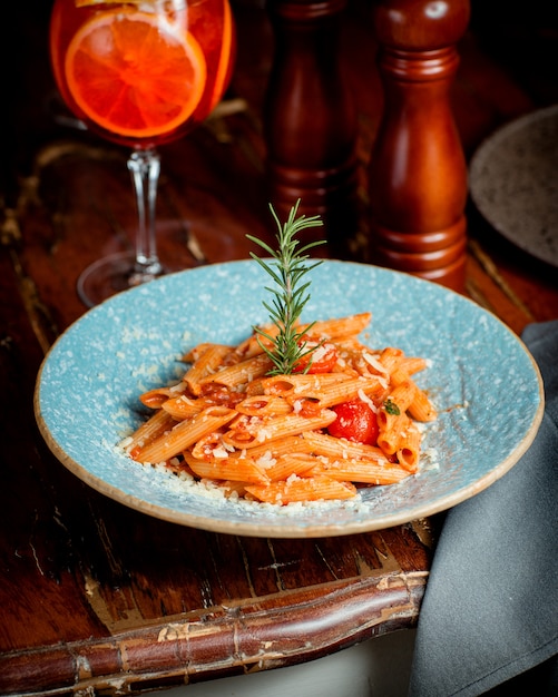 Free photo a plate of penne paste with tomato sauce and parmesan