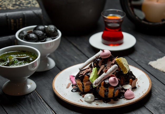 Free photo a plate of profiteroles served with chocolate sauce