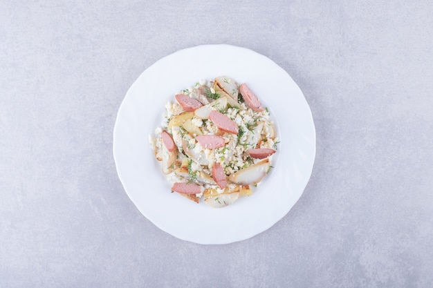 Free Photo plate of salad with sausages on stone background.