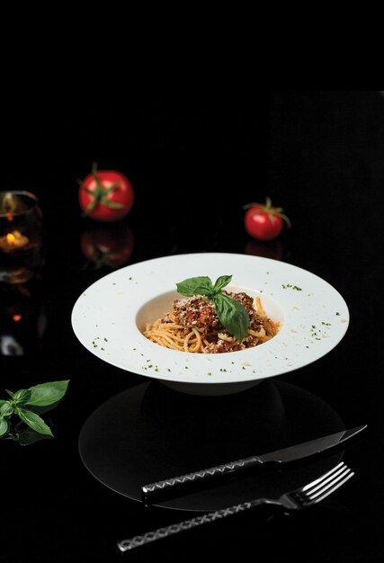 A plate of spaghetti in dark restaurant.