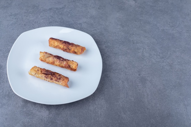 A plate of sumac over meaty pancakes on the wooden plate on marble table.