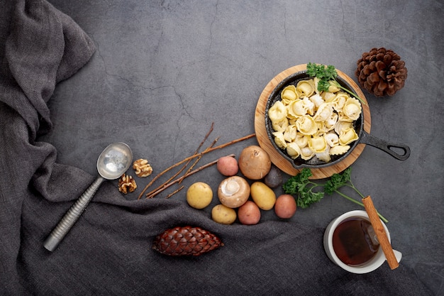 Free Photo plate of tortellini and mushrooms on a grey background