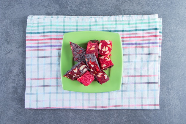 Free Photo a plate of turkish delights on a tea towel , on the marble background.