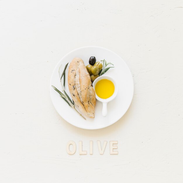 Plate with bread olives and oil with olive word