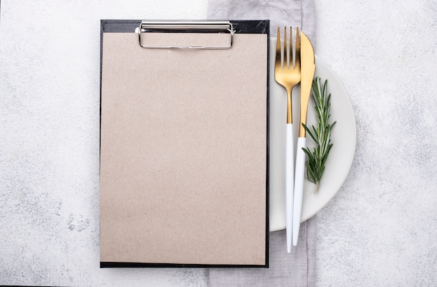 Plate with cutlery and clipboard